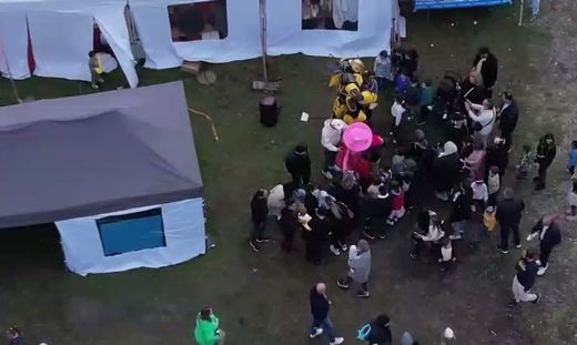 Ziyaretçiler çadırların arasında / Besucher zwischen den Zelten